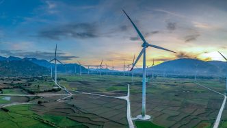 Aerogeneradores en un valle con montañas al atardecer